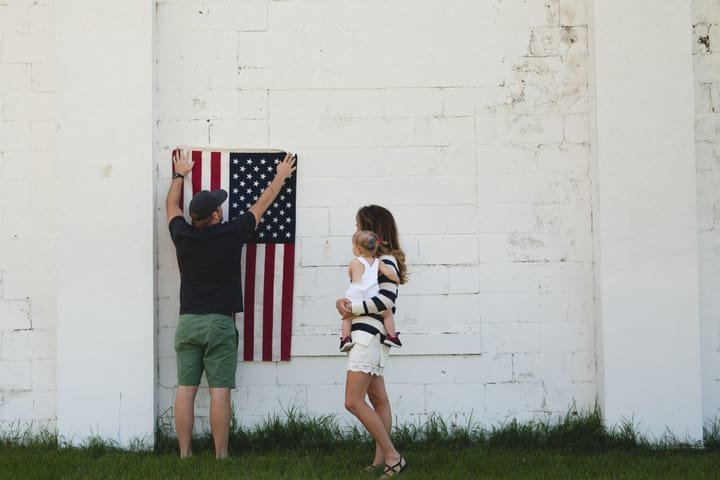 A family celebrating outdoors with an American flag